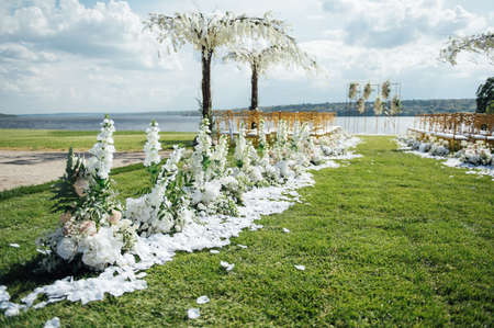 Premium arch for wedding ceremony for newlyweds on the river bank with wisteria treesの写真素材