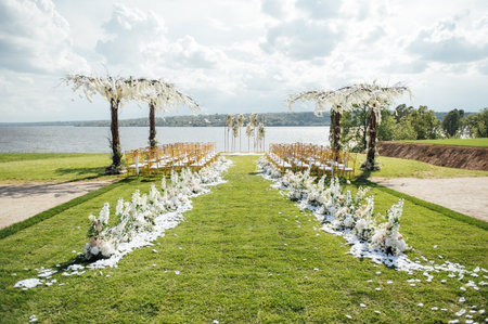 Premium arch for wedding ceremony for newlyweds on the river bank with wisteria treesの写真素材
