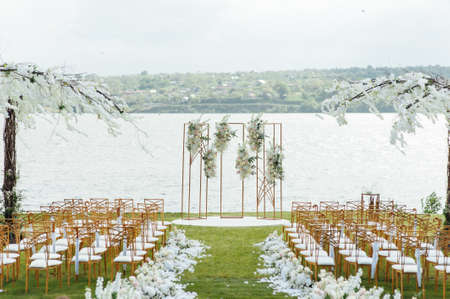 Premium arch for wedding ceremony for newlyweds on the river bank with wisteria treesの写真素材