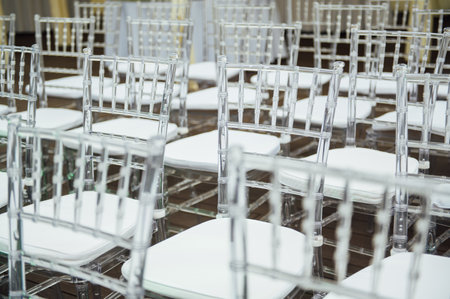 Glass chairs stand in a row in a beautiful wedding outing ceremonyの写真素材