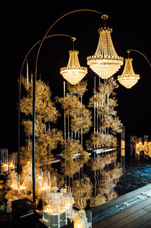 candle light in glass lanterns and gorgeous lamp at luxury wedding ceremony in evening, decor and arrangementsの写真素材