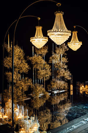 candle light in glass lanterns and gorgeous lamp at luxury wedding ceremony in evening, decor and arrangementsの写真素材