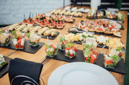 Buffet table of reception with cold snacks, meat and saladsの写真素材