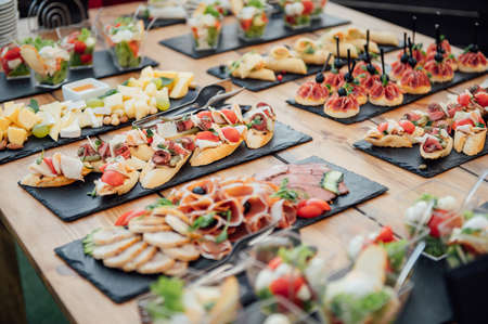 Buffet table of reception with cold snacks, meat and saladsの写真素材