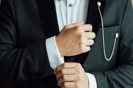 Hands of wedding groom getting ready in suitの写真素材