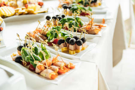 Sandwiches, canapes and cakes on the festive table. A wide variety of snacksの写真素材
