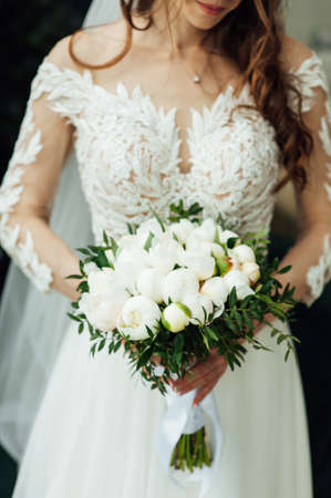 Beautiful wedding bouquet of flowers in hands of the brideの写真素材