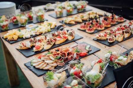 Buffet table of reception with cold snacks, meat and saladsの写真素材