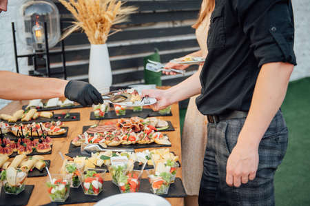 Buffet table of reception with cold snacks, meat and saladsの写真素材