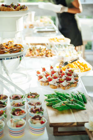 Buffet table of reception with cold snacks, meat and saladsの写真素材