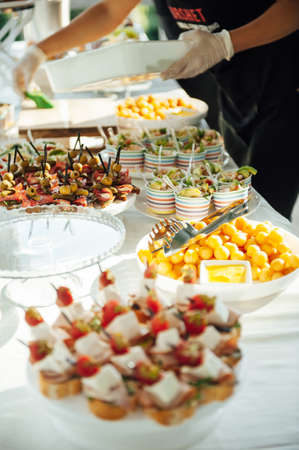 Buffet table of reception with cold snacks, meat and saladsの写真素材