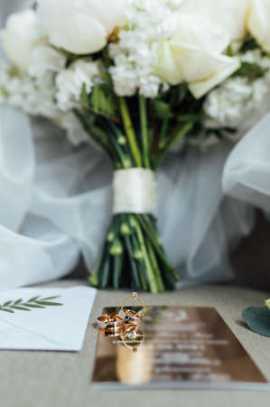 Wedding details flat lay. Wedding invitation and scroll paper. Bottle with fragrance. Simple bouquetの写真素材
