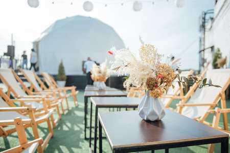 On the table is a decorative vase with dried flowers. Beautiful summer location for relaxationの写真素材
