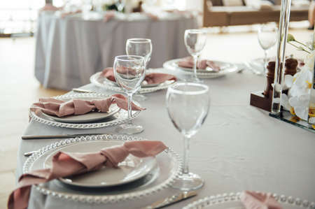 Luxurious restaurant. Luxurious interior, white tables, serving dishes and glasses for guestsの写真素材
