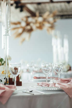 Luxurious restaurant. Luxurious interior, white tables, serving dishes and glasses for guestsの写真素材