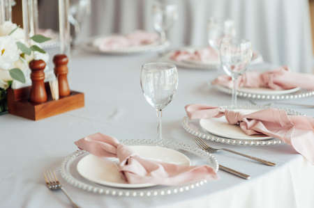Luxurious restaurant. Luxurious interior, white tables, serving dishes and glasses for guestsの写真素材