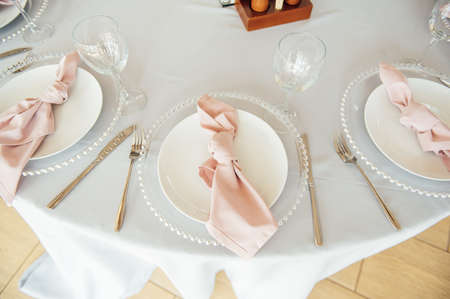 Luxurious restaurant. Luxurious interior, white tables, serving dishes and glasses for guestsの写真素材