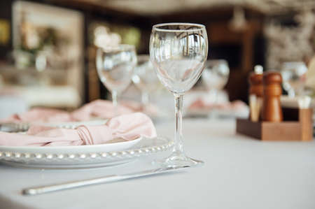 Luxurious restaurant. Luxurious interior, white tables, serving dishes and glasses for guestsの写真素材