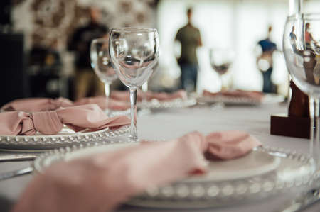 Luxurious restaurant. Luxurious interior, white tables, serving dishes and glasses for guestsの写真素材