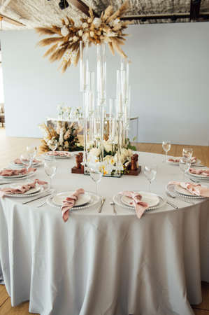Luxurious restaurant. Luxurious interior, white tables, serving dishes and glasses for guestsの写真素材