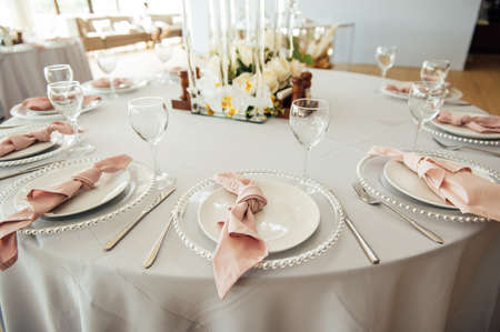 Luxurious restaurant. Luxurious interior, white tables, serving dishes and glasses for guestsの写真素材