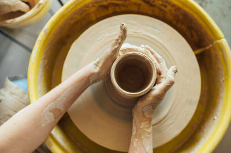 Hands of a potter. Potter making ceramic pot on the pottery wheelの写真素材