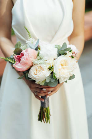 Beautiful wedding bouquet in hands of the brideの写真素材
