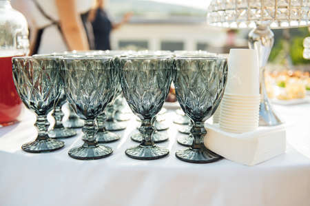 Elegant blue glasses without champagne stand in row next to canapes and snacks on picturesque background.の写真素材