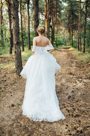 Beautiful wedding bride running in the gardenの写真素材