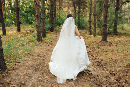 Beautiful wedding bride running in the gardenの写真素材