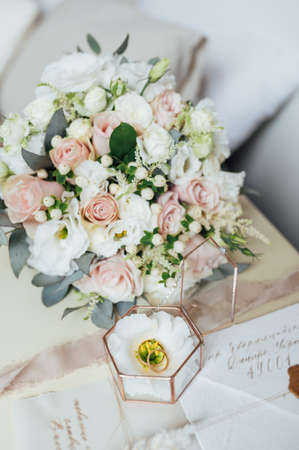 Beautiful wedding bouquet and rings of the newlyweds near the invitation cards. Boho styleの写真素材