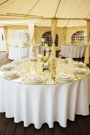 Luxurious restaurant. Luxurious interior, white tables, serving dishes and glasses for guestsの写真素材