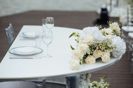 Luxurious restaurant. Luxurious interior, white tables, serving dishes and glasses for guestsの写真素材
