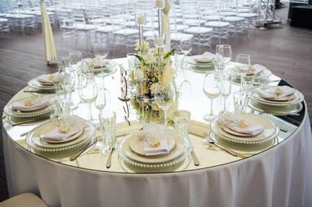 Luxurious restaurant. Luxurious interior, white tables, serving dishes and glasses for guestsの写真素材