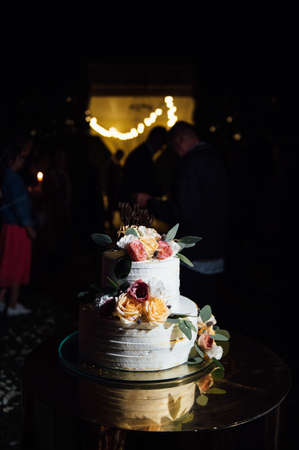 Beautiful wedding arch with flowers and a large wedding cake.
