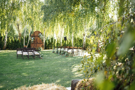 A beautiful area for an outdoor wedding ceremony. Arch Decorated with a large wooden door with many flowers.の写真素材