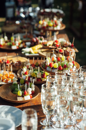 Table of various snacks, sandwiches, strawberries and champagne glasses. Buffet for wedding guestsの写真素材