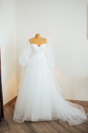 The brides dress hangs on the window. A gentle bouquet of the bride and womens shoes stand on the windowsillの写真素材