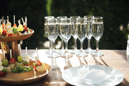 Table of various snacks, sandwiches, strawberries and champagne glasses. Buffet for wedding guestsの写真素材