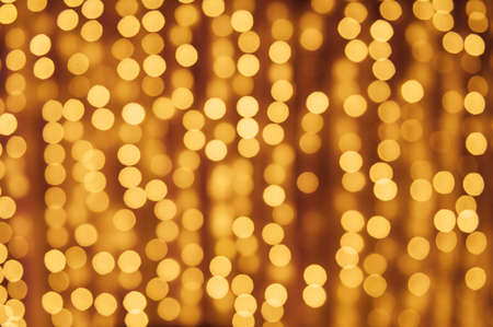 Abstract defocused yellow light on black background. Bokeh photo of LED light.の写真素材