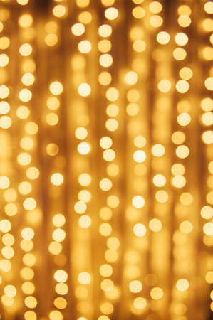 Abstract defocused yellow light on black background. Bokeh photo of LED light.の写真素材