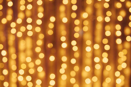 Abstract defocused yellow light on black background. Bokeh photo of LED light.の写真素材