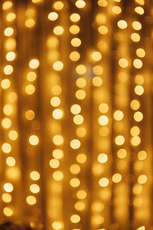 Abstract defocused yellow light on black background. Bokeh photo of LED light.の写真素材