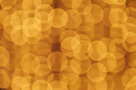 Abstract defocused yellow light on black background. Bokeh photo of LED light.の写真素材