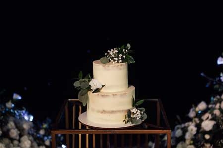 Beautiful wedding cake with flowers and a large wedding arch.の写真素材