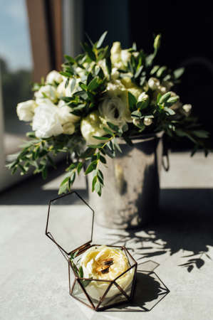 Bridal bouquet and wedding rings on windowの写真素材