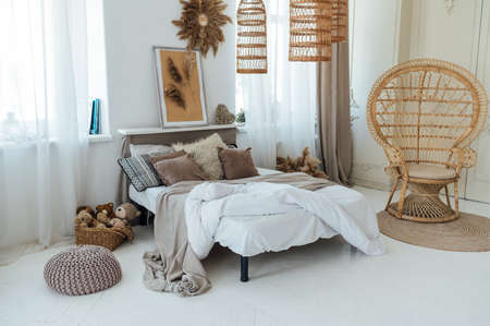 Comfortable bed with warm knitted plaid in stylish room interiorの写真素材
