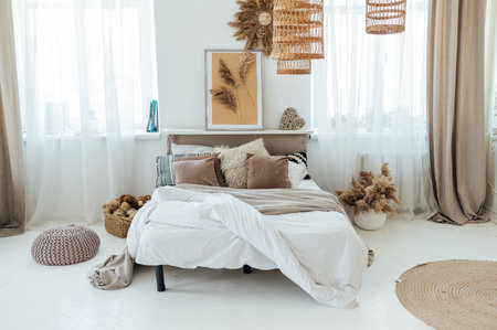 Comfortable bed with warm knitted plaid in stylish room interiorの写真素材