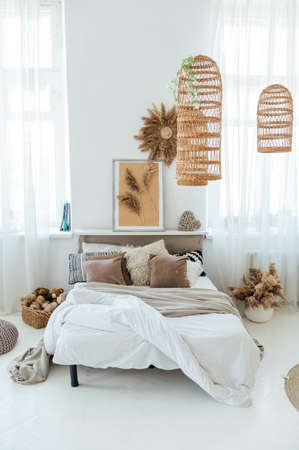 Comfortable bed with warm knitted plaid in stylish room interiorの写真素材