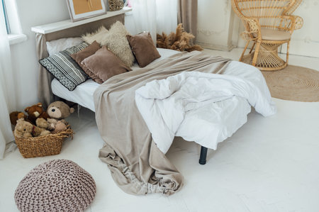Comfortable bed with warm knitted plaid in stylish room interiorの写真素材